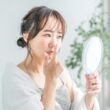 鏡を見ながら小鼻の毛穴をチェックする女性